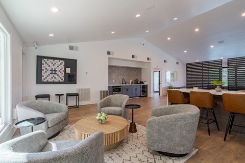 A living room with grey chairs and a wooden coffee table.