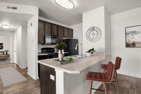 A kitchen with a brown chair and a white counter.