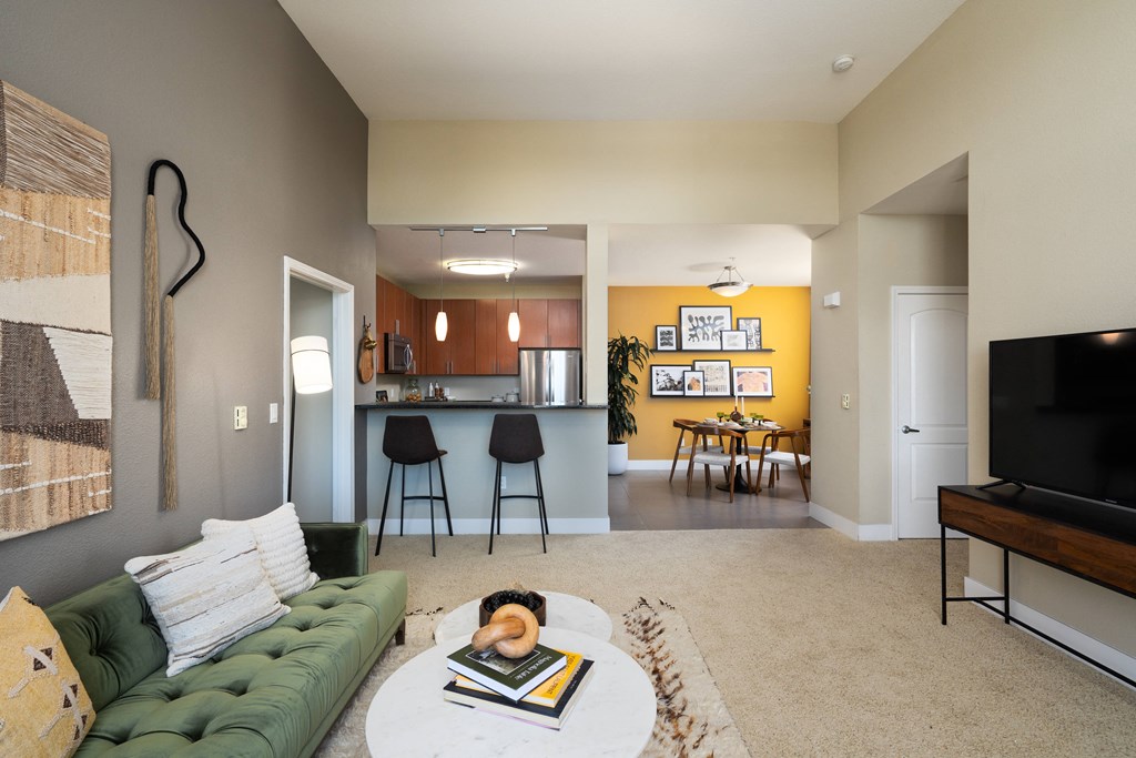the view from the living room into the kitchen and dining room of an apartment