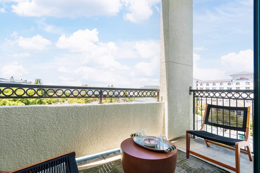 a balcony with a table and chairs and a view of the ocean