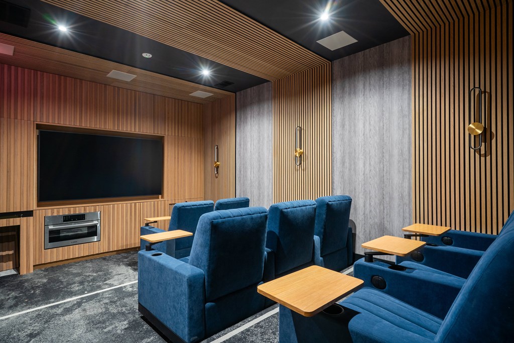 a cinema room with blue chairs and a television