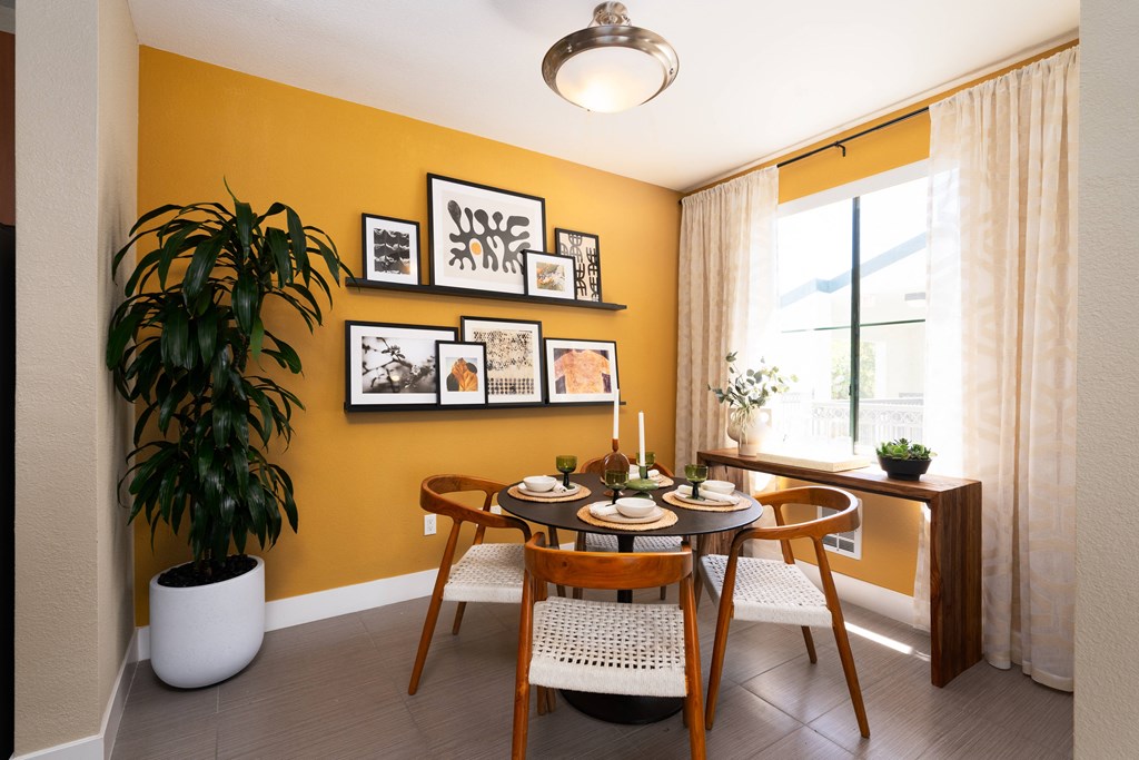 a dining room with a table and chairs and a plant