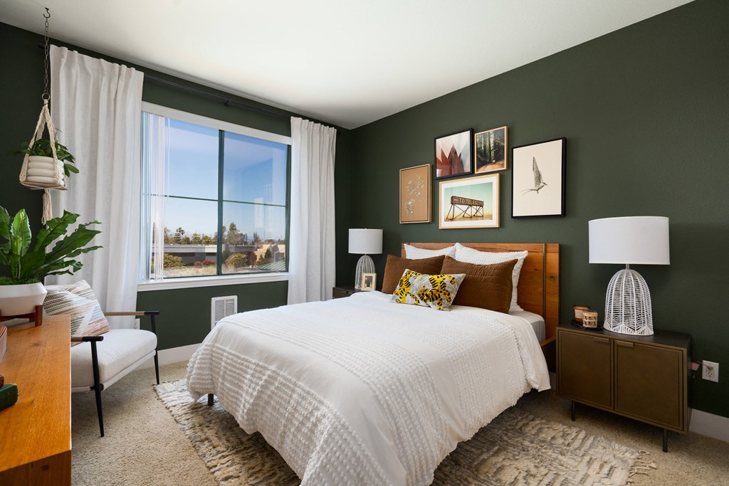 a bedroom with green walls and a white bed