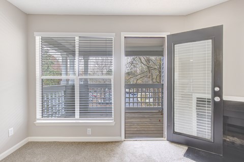A room with a sliding door and a window with blinds.