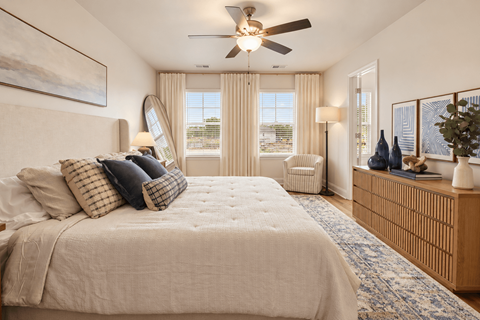 A bedroom with a large bed and a ceiling fan.