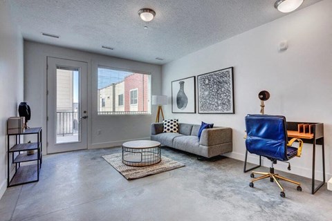 a living room with a couch and a chair and a door