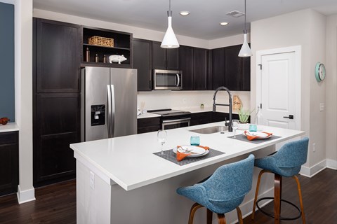 A kitchen with a white counter top and blue chairs.