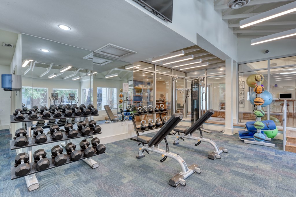 a spacious fitness center with cardio machines and weights