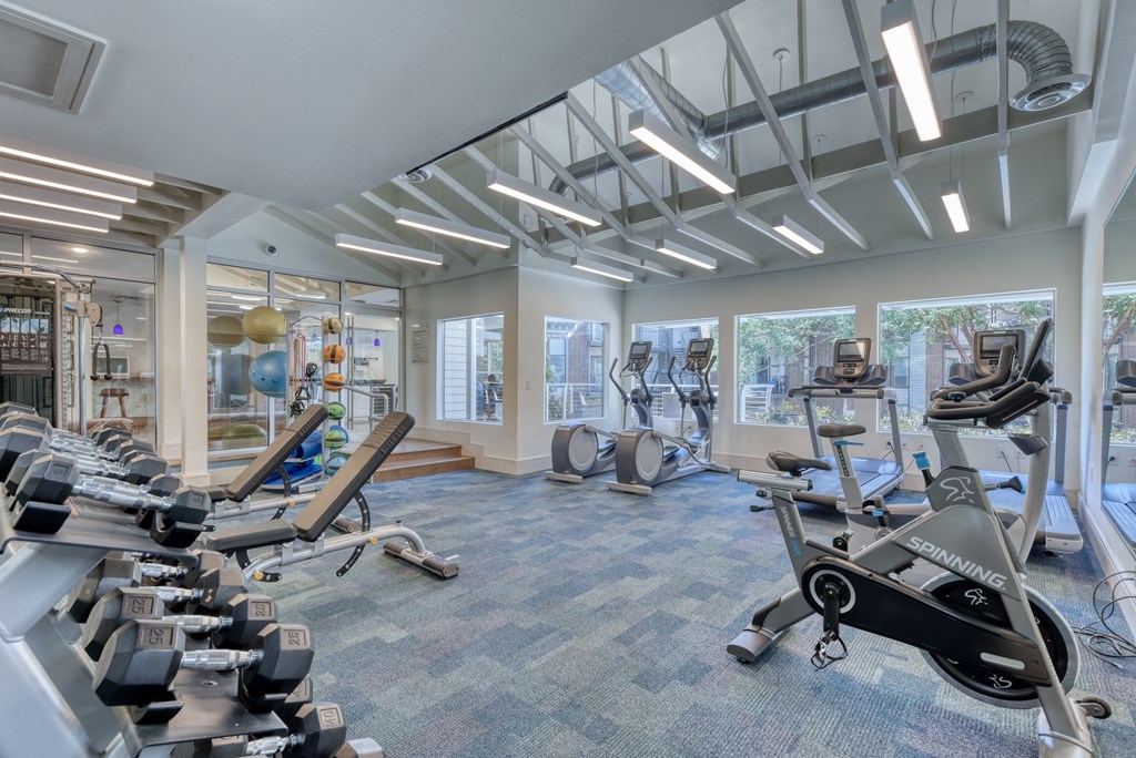 a spacious fitness center with treadmills and elliptical machines