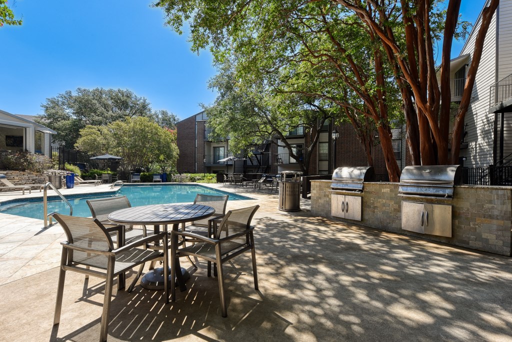 a patio with a table and chairs next to a pool