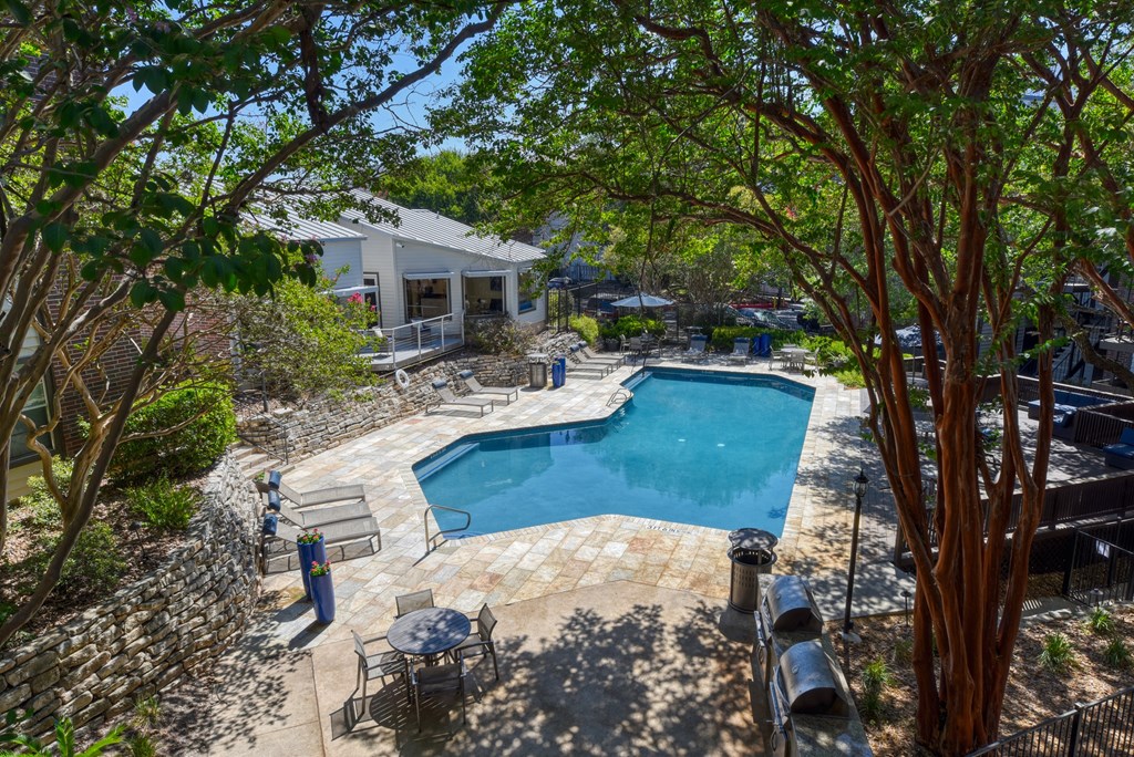a backyard with a pool and patio with a house in the background