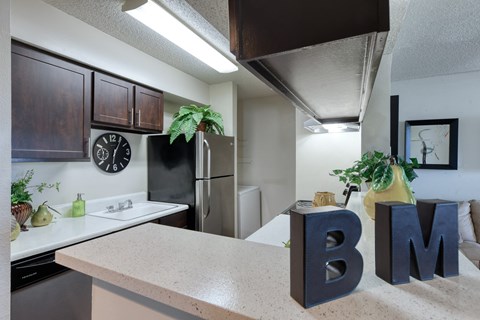 full kitchen with stainless steel appliances and granite counter top with bmn letters on it