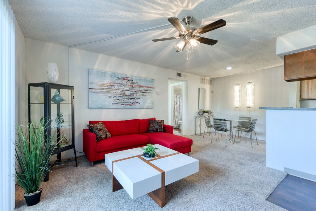 a living room with a red couch and a white coffee table