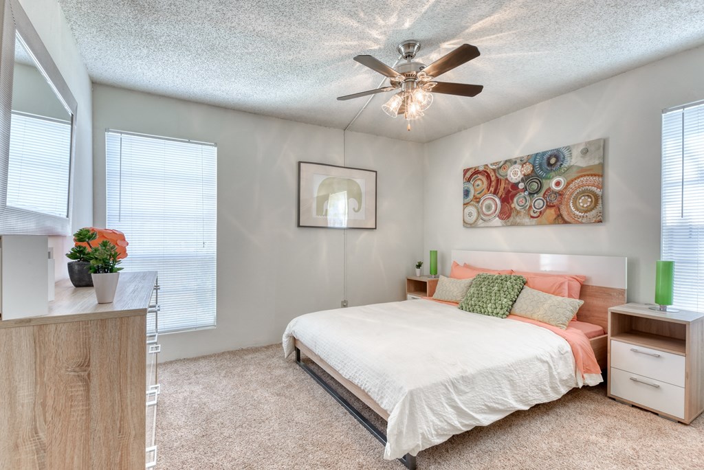 a bedroom with a bed and a ceiling fan