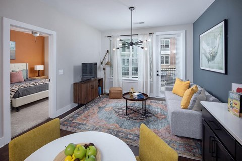 A living room with a white table and yellow chairs.