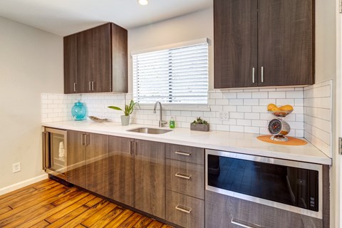 A kitchen with wooden cabinets and a white tile backsplash.