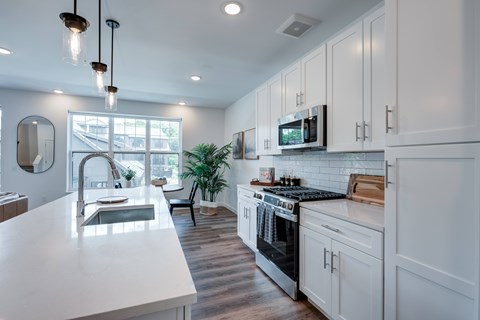 A modern kitchen with white cabinets and a large island.