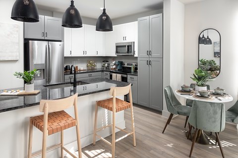 A kitchen with a table and chairs.