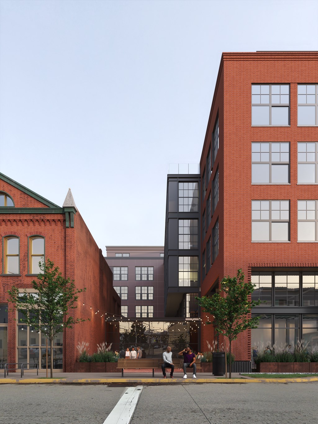 A red brick building with a black building next to it and people walking in front of the red brick building.