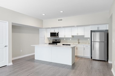 Renovated kitchen with white cabinets and white countertops