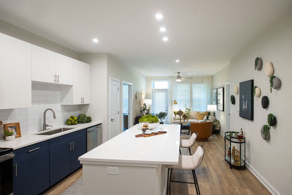 a kitchen and living room with a white counter top