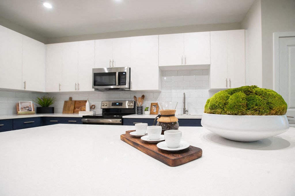 a white kitchen with white counters and a white counter top