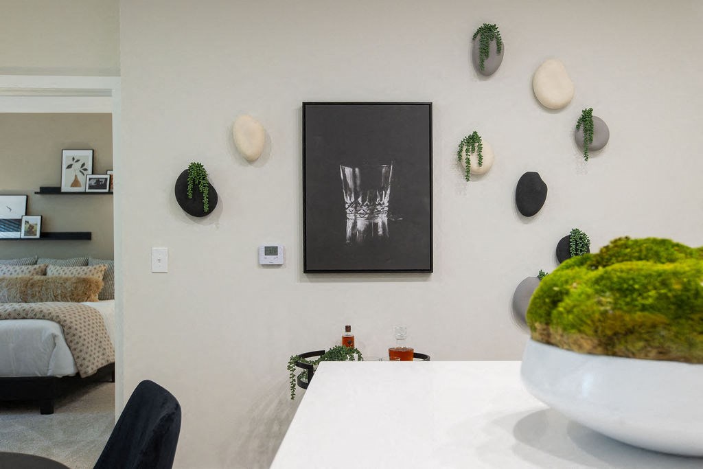 a white kitchen with a table and a picture on the wall
