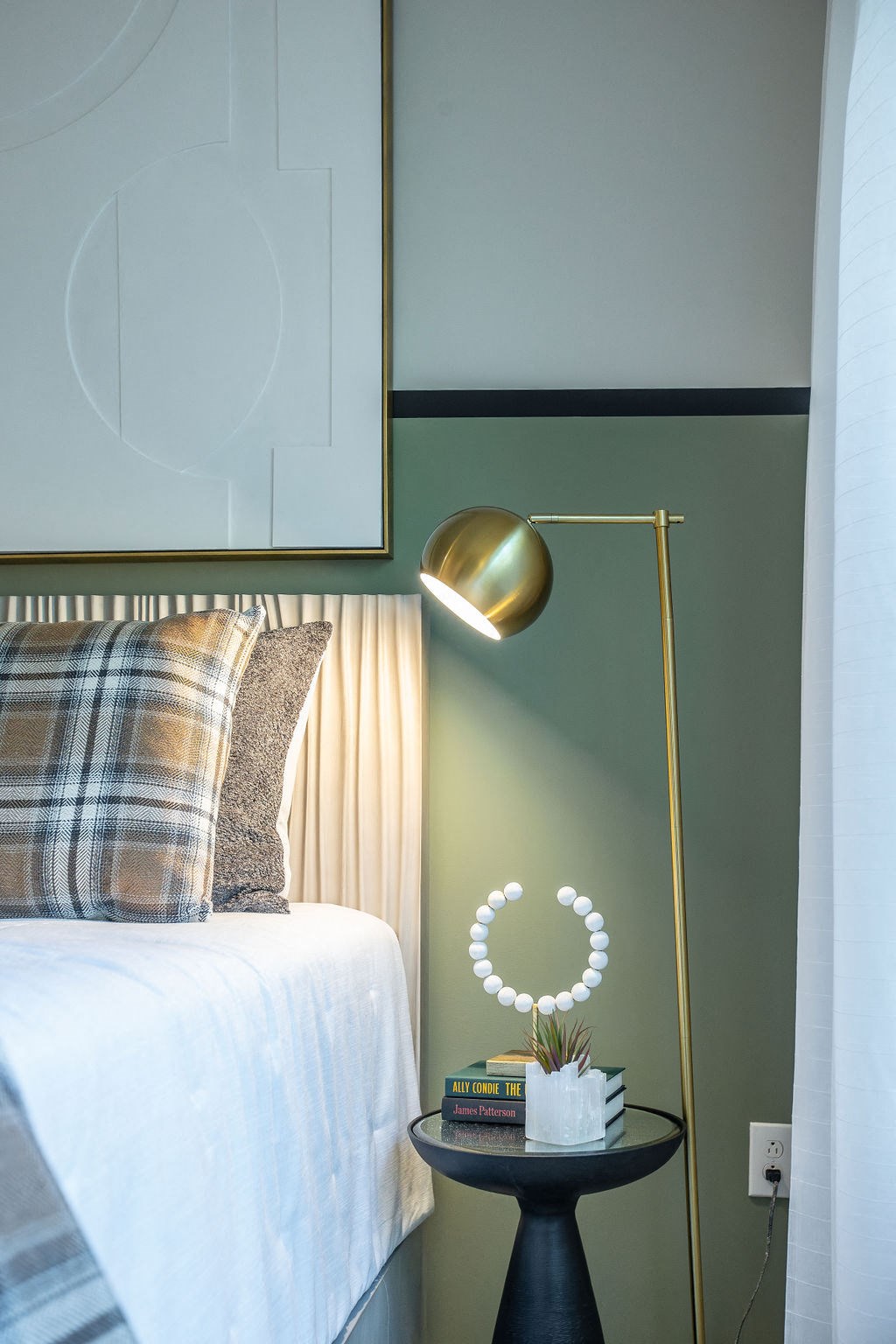 a bedroom with a bed and a lamp and a table