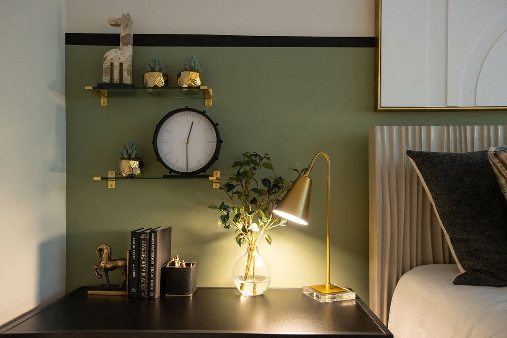a desk with a lamp and a clock on a wall