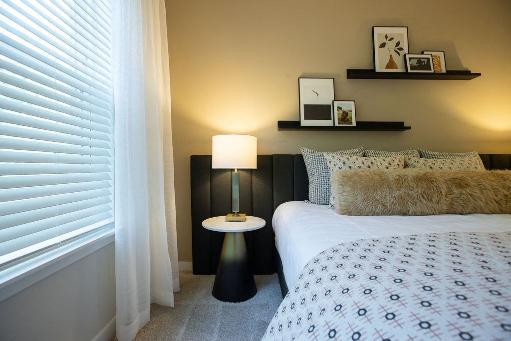 a bedroom with a bed and a lamp and a window