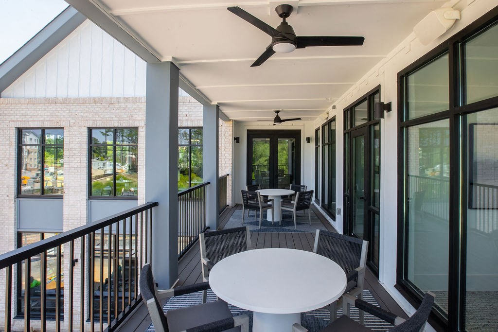 a porch with a table and chairs and a ceiling fan