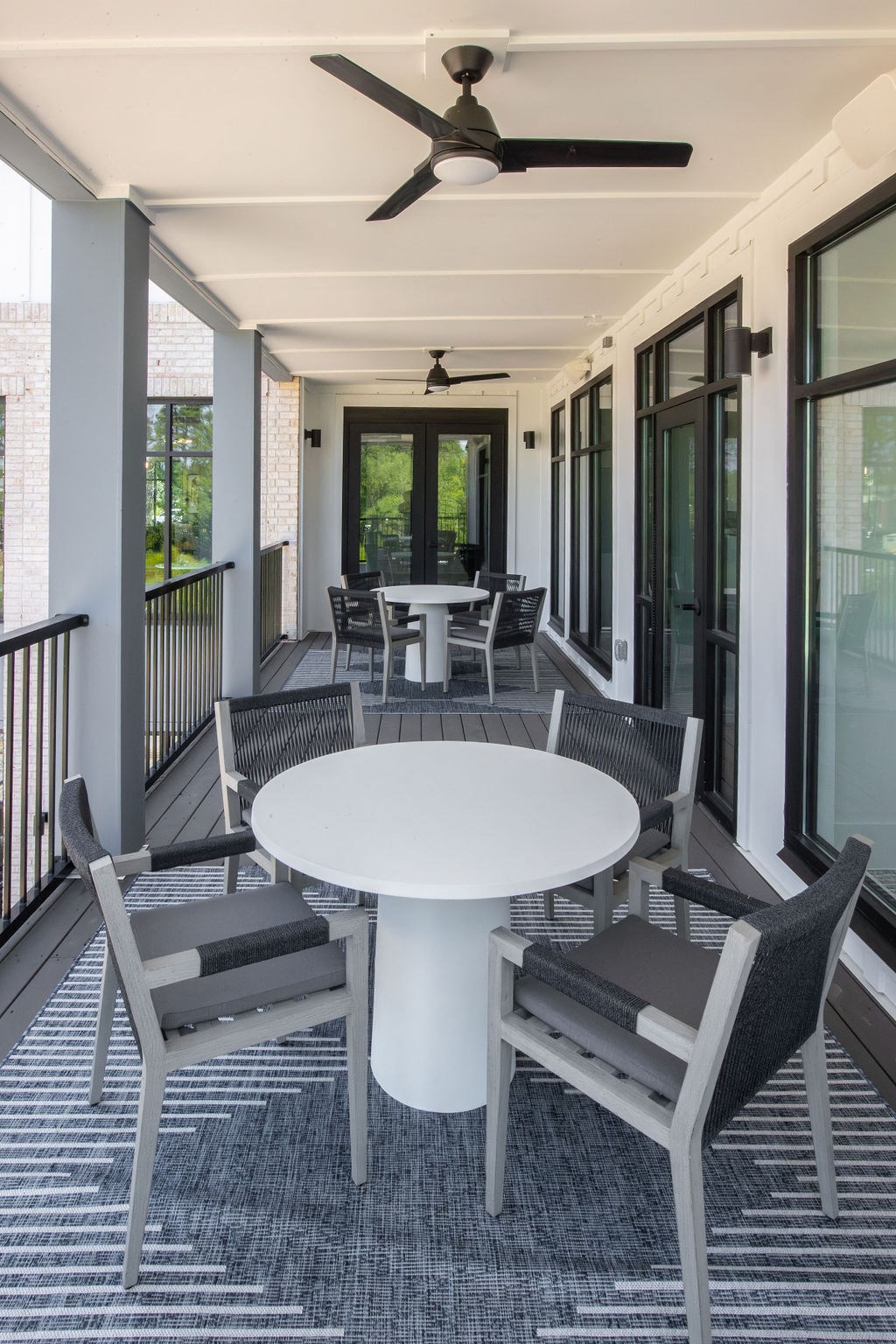 a covered porch with a white table and chairs