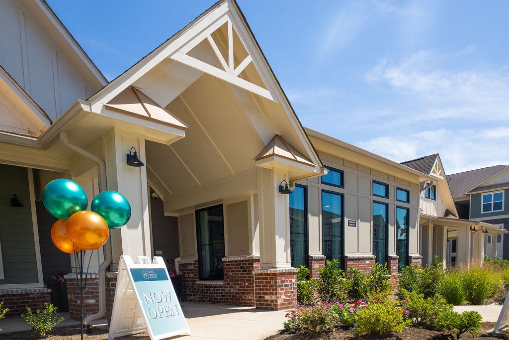 the exterior of a building with a sign and balloons
