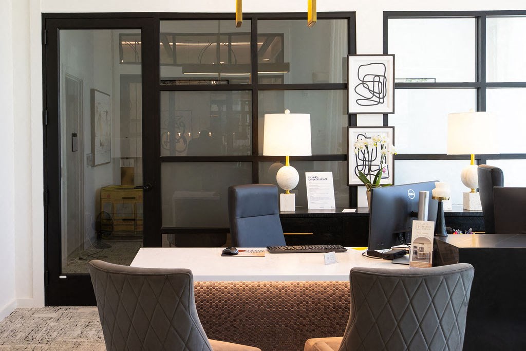 a desk with a computer and chairs in an office