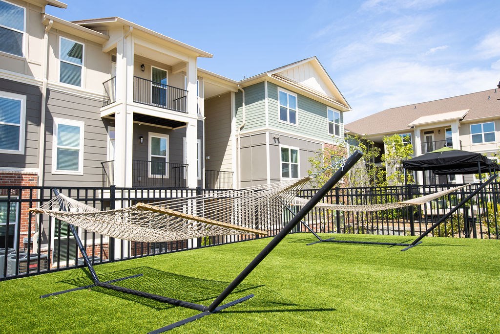 a hammock in the yard of an apartment building