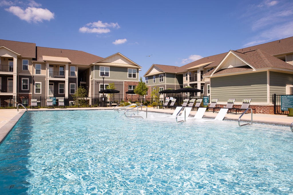 a swimming pool in front of a row of apartment buildings