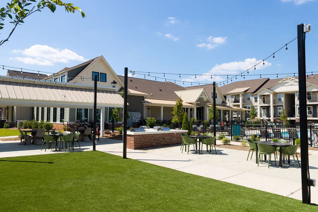 a patio with tables and chairs in front of houses