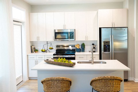 a kitchen with white cabinets and stainless steel appliances