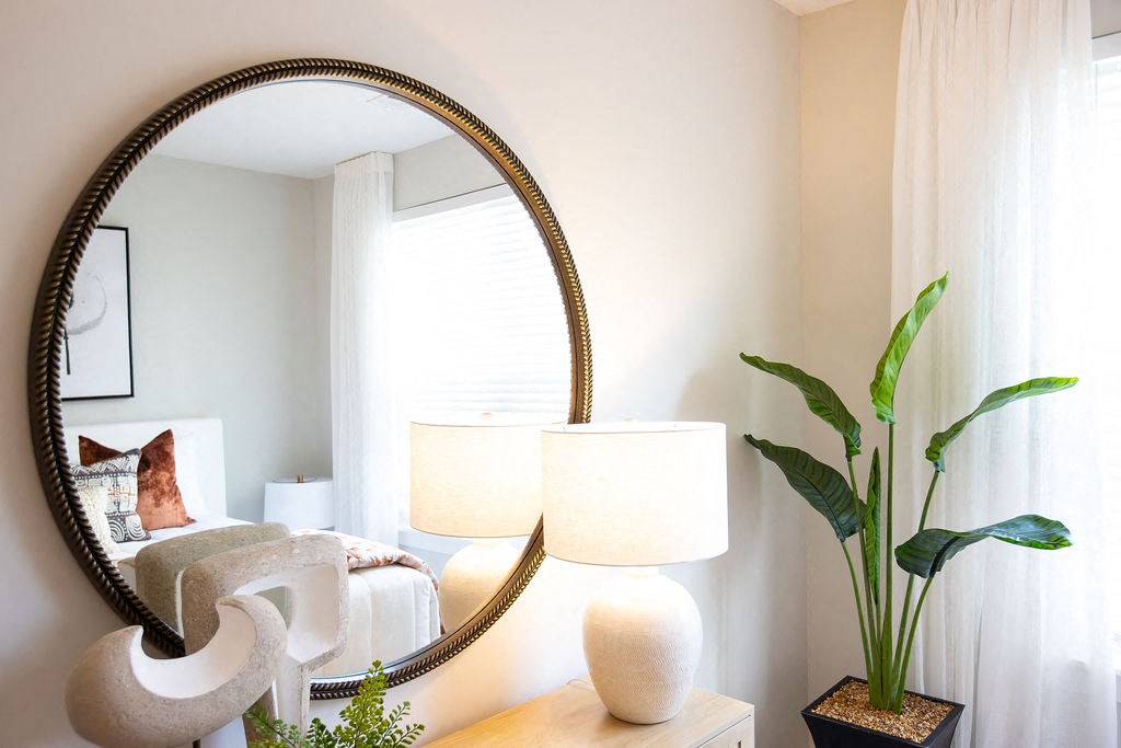 a bedroom with a large mirror on the wall