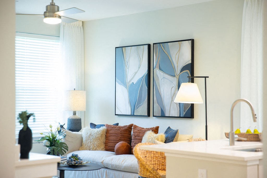 a living room with a couch and two paintings on the wall
