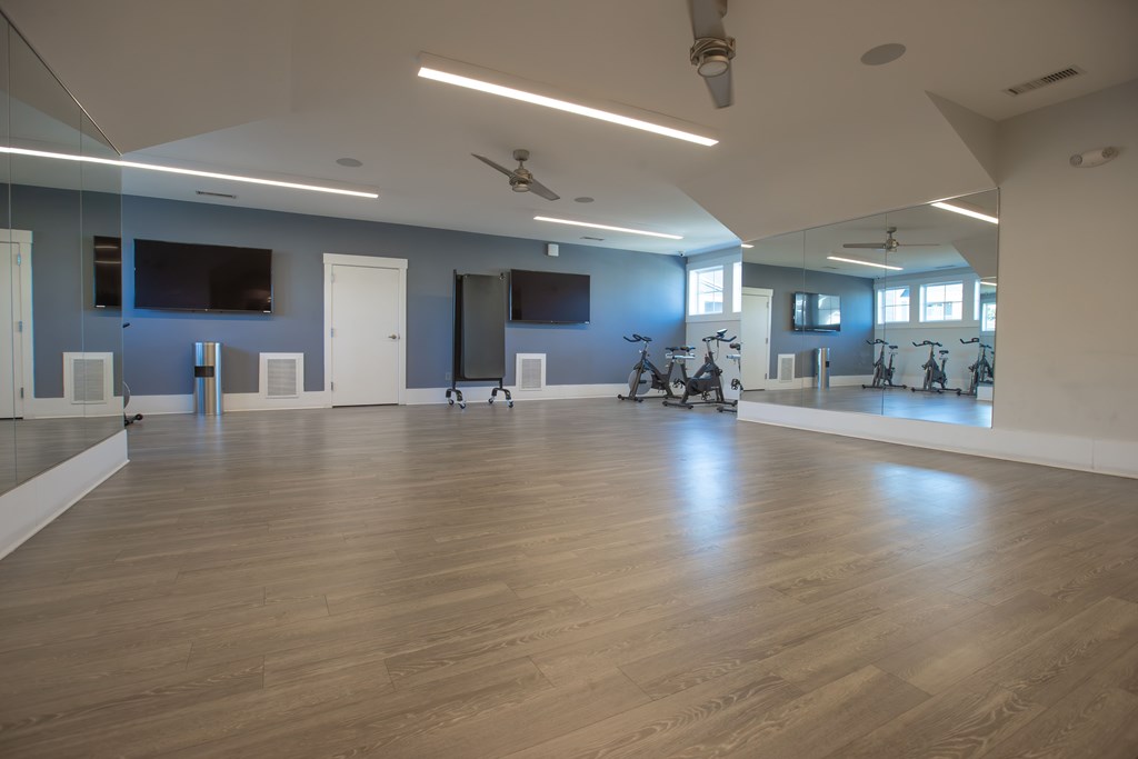A room with wooden floors and mirrors on the wall.