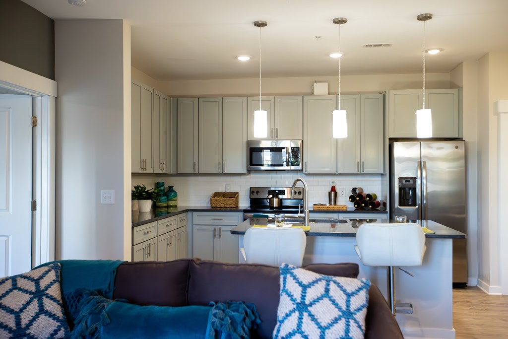 A modern kitchen with a dining area and a couch.