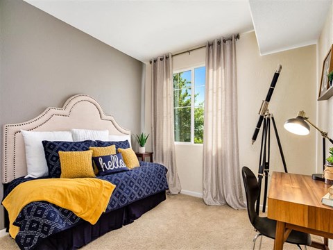 furnished model bedroom blue and yellow sheets