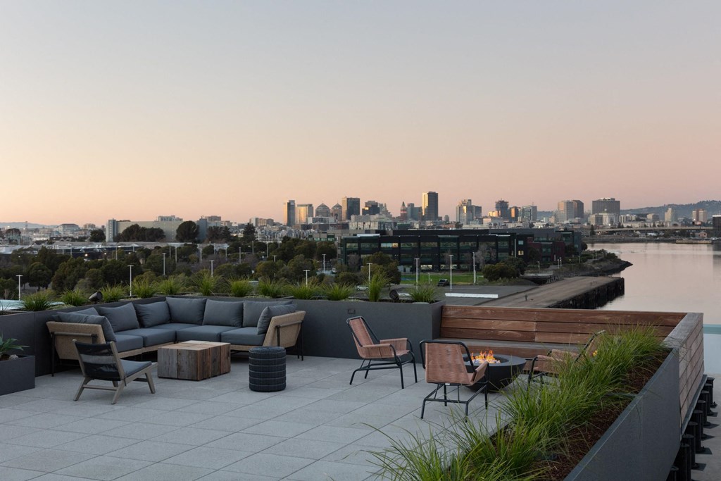 a terrace with furniture and a city skyline in the background