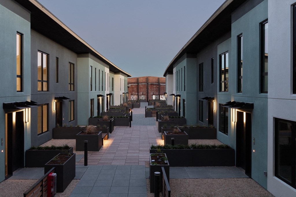 a row of apartments with a courtyard at dusk