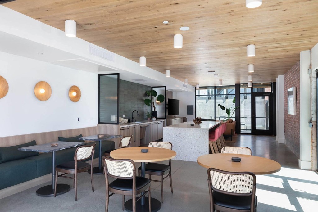 a large room with tables and chairs and a kitchen