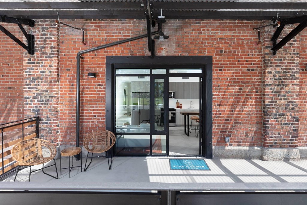 the back of the building has a patio with tables and chairs