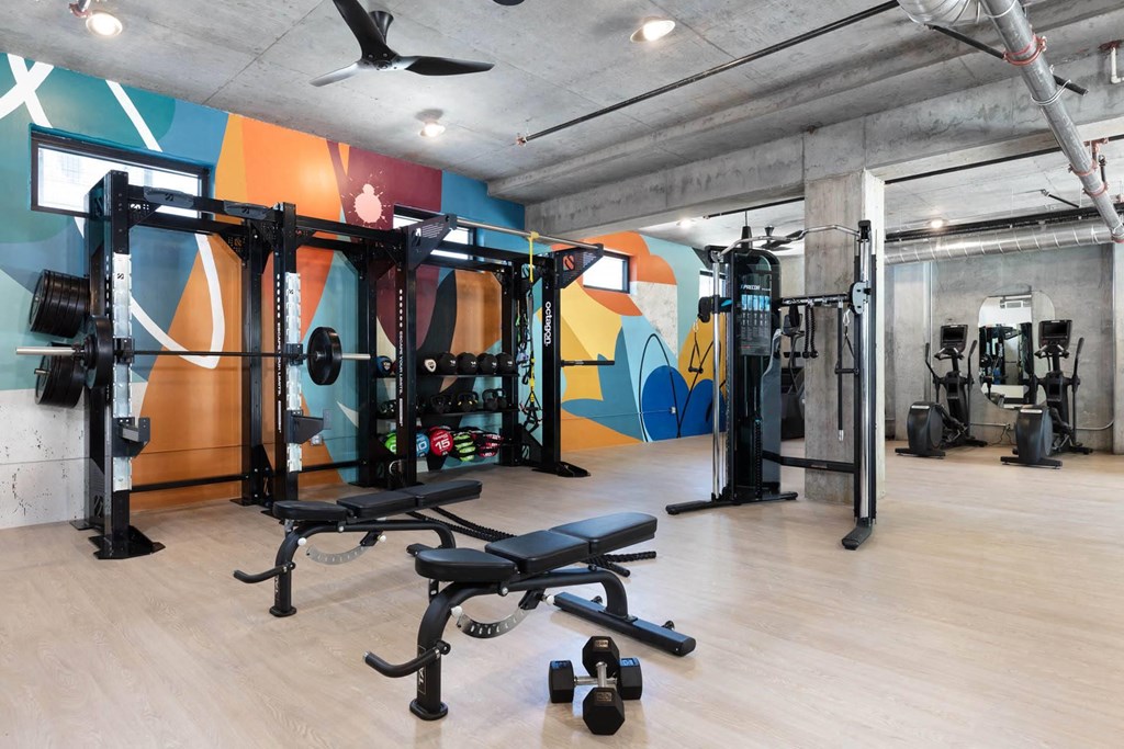 a gym with weights and a wall with graffiti