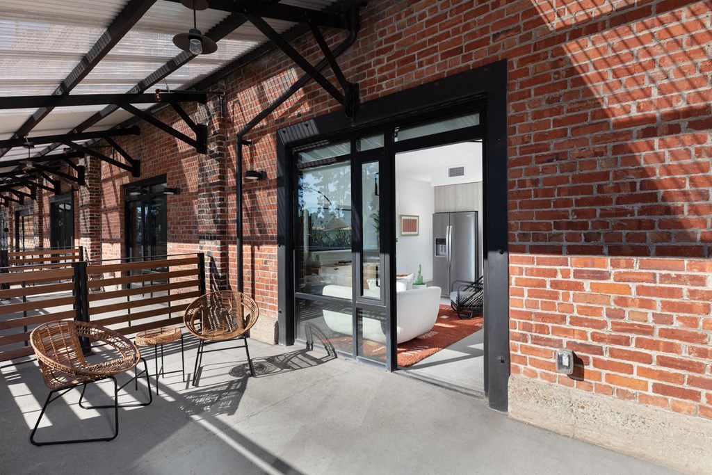 a balcony with a brick wall and a glass door