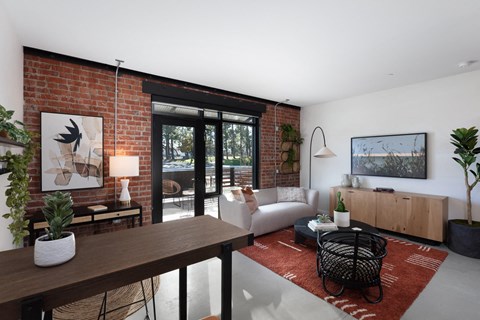 a living room with a brick wall and a sliding glass door